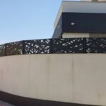 Instalación de vallas metálicas en jardín exterior con diseño moderno de lineas entrelazadas, en aluminio y lacadas en color negro en madrid
