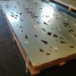 Taller de metalistería fabricando placas de acero con patrón geométrico a medida para el cerramiento de un chalet en Madrid.