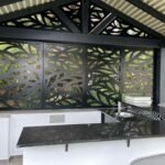 Instalación de pérgola de diseño con celosías metálicas para exteriores, con diseño de hojas lacado al horno en color negro en Málaga