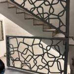 Instalación de barandillas para escaleras interiores modernas con diseño de cuadros entrelazados en corte laser, en color gris claro en Málaga