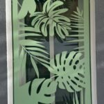 Reja metálica para ventana en un original tono verde claro, destacando un diseño botánico personalizado de hojas tropicales y monstera en corte láser. Instalación de seguridad exterior a medida para una vivienda en la zona de Coín, Málaga.