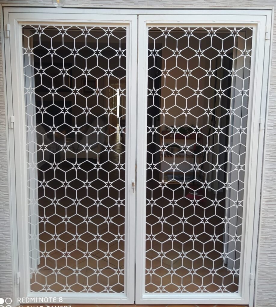 Modelo de reja para puerta exterior abatible de dos hojas con corte láser geométrico en color blanco
