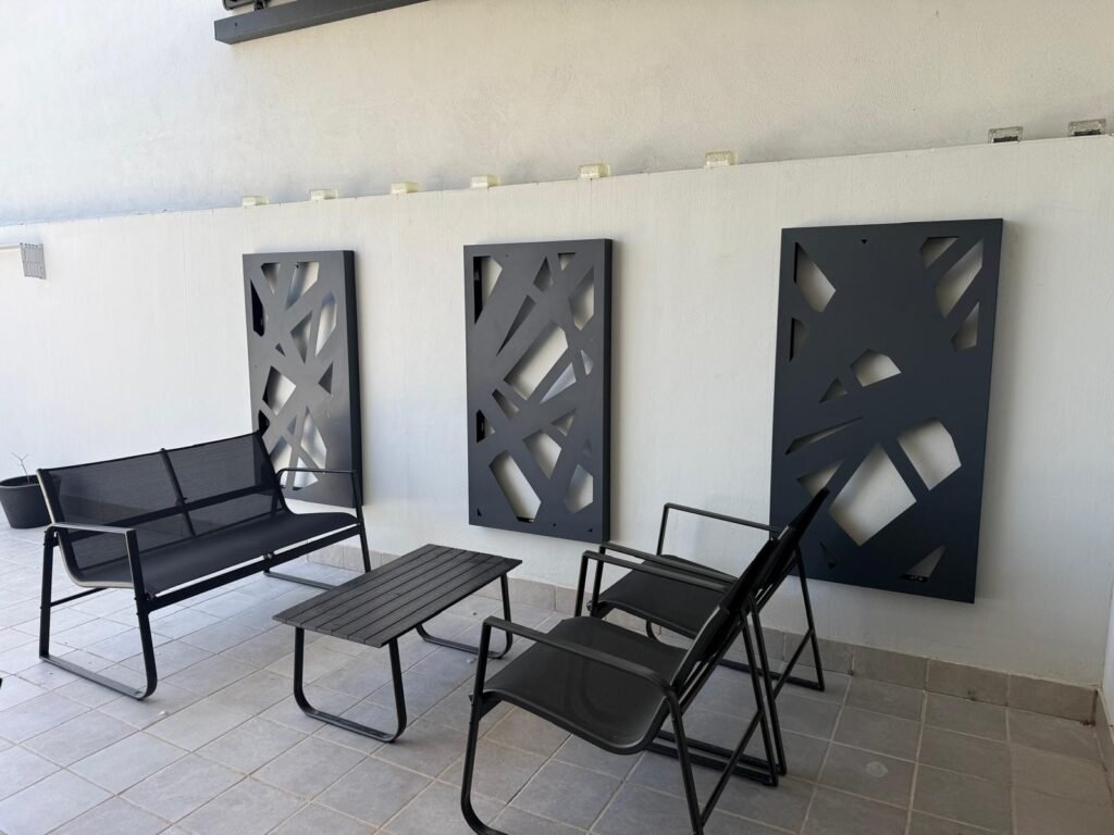 Arquitectura interior en metal a medida con paneles decorativos de corte láser, cuadros de diseño de lineas entrecruzadas en color negro mate