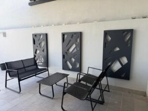 Arquitectura interior en metal a medida con paneles decorativos de corte láser, cuadros de diseño de lineas entrecruzadas en color negro mate