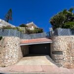Valla metálica sobre muro de piedra en villa de Málaga con diseño geométrico para seguridad antirrobo.