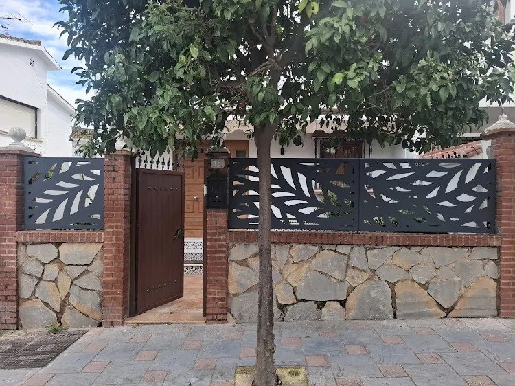 Valla de diseño , para vivienda unifamiliar con patio delantero, en color negro con diseño de hojas en Fuengirola