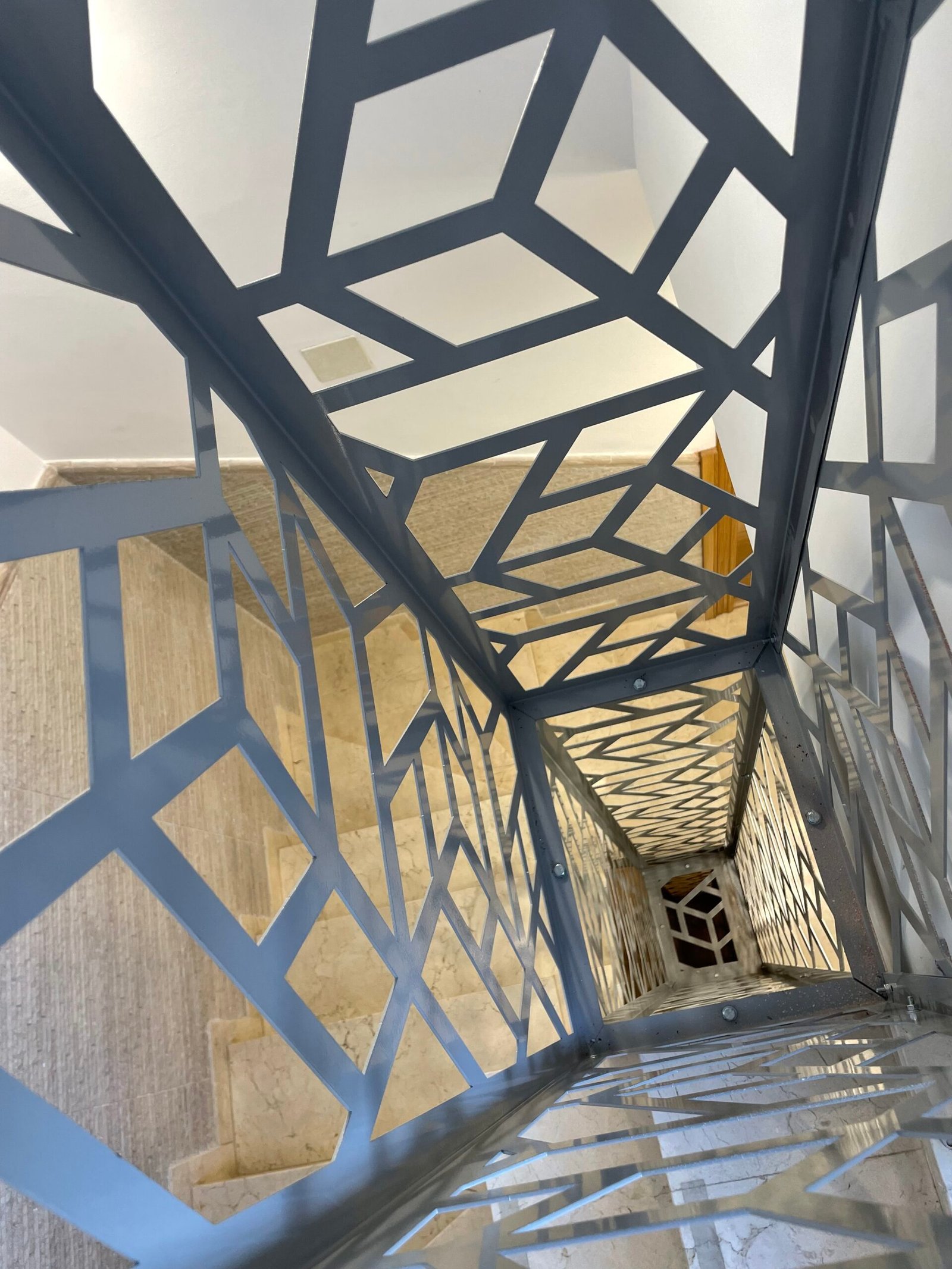 Instalacion de Celosía metálica separador de ambientes fabricada a medida con corte láse, para escalera interior, color gris en Estepona