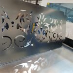 Panel de chapa metálica con acabado brillante y diseño ornamental curvo, fabricado a medida mediante tecnología de corte láser.